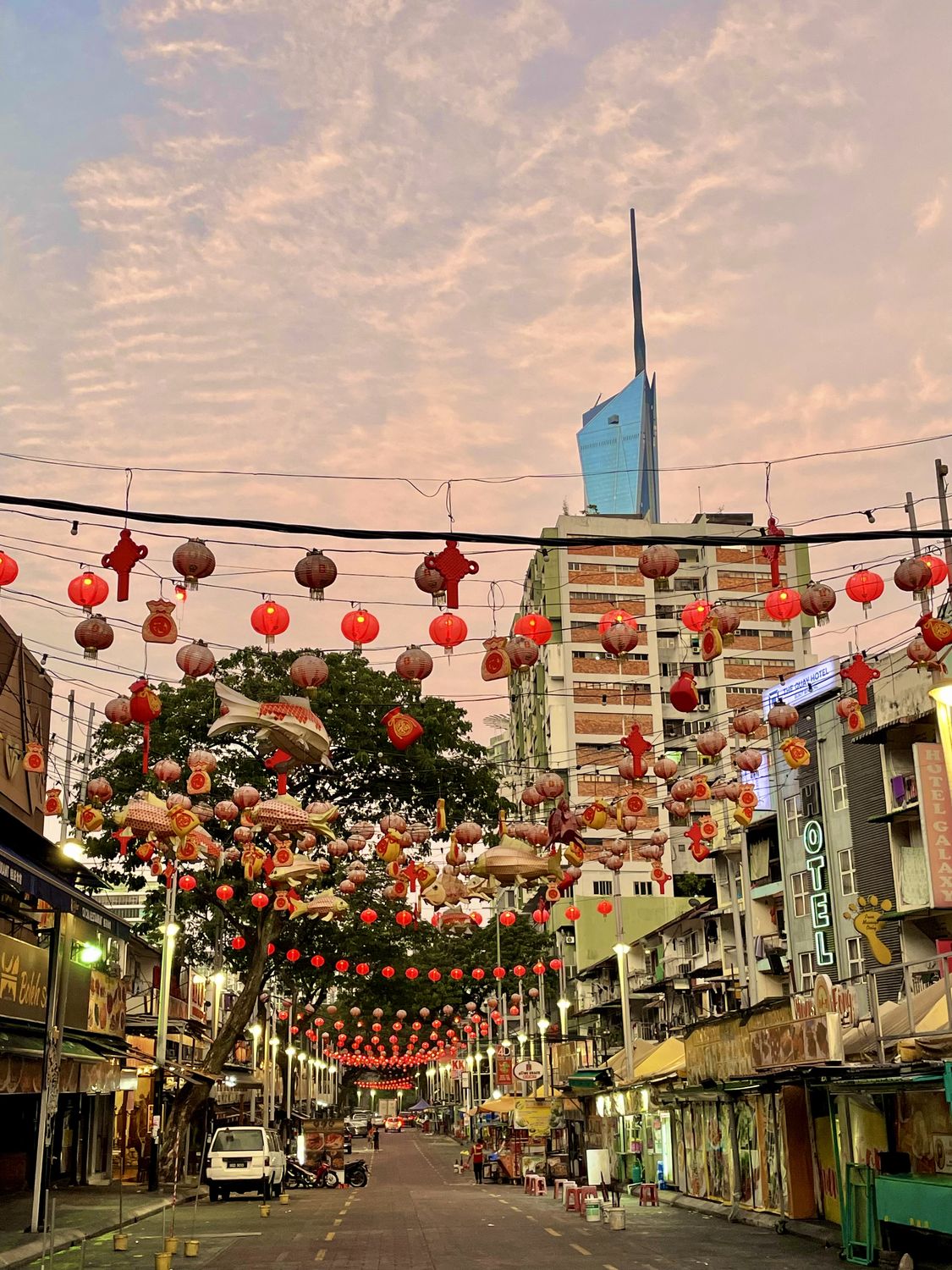Red lanterns strung above a Chinatown street at dusk