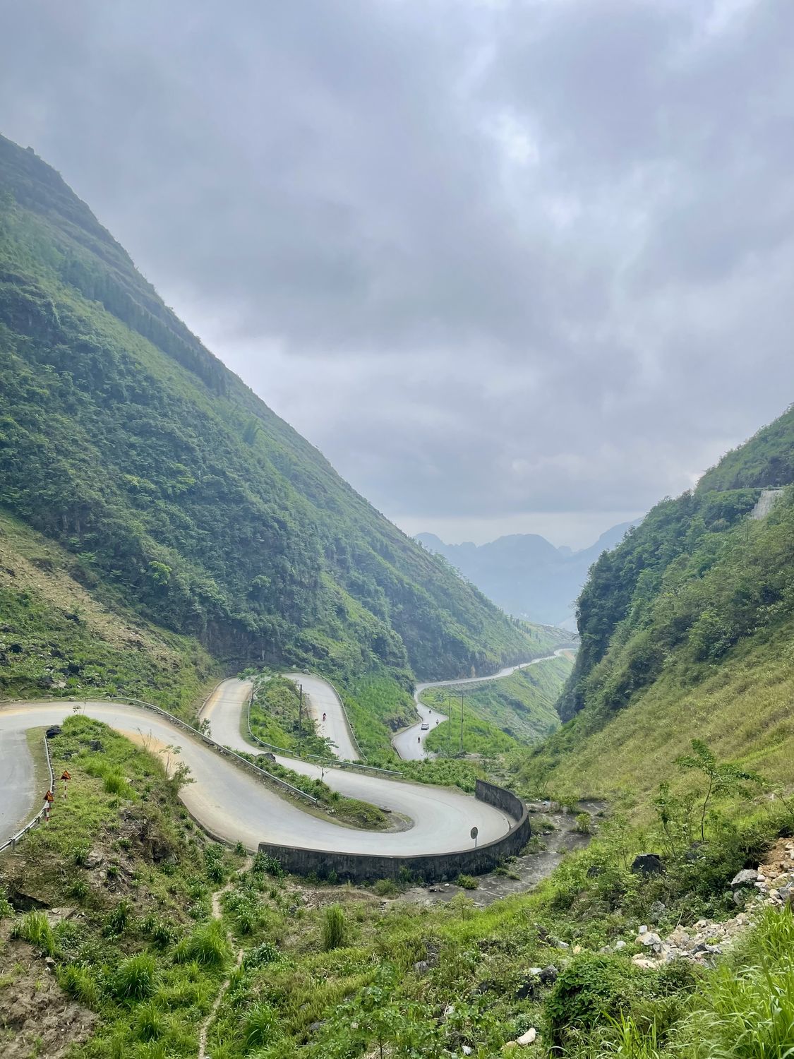 A switchback road descending through a green mountain valley
