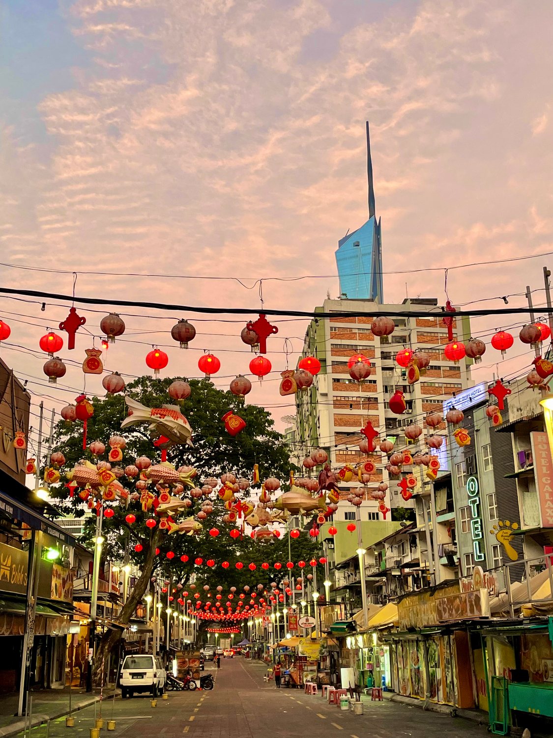 Red lanterns strung above a Chinatown street at dusk