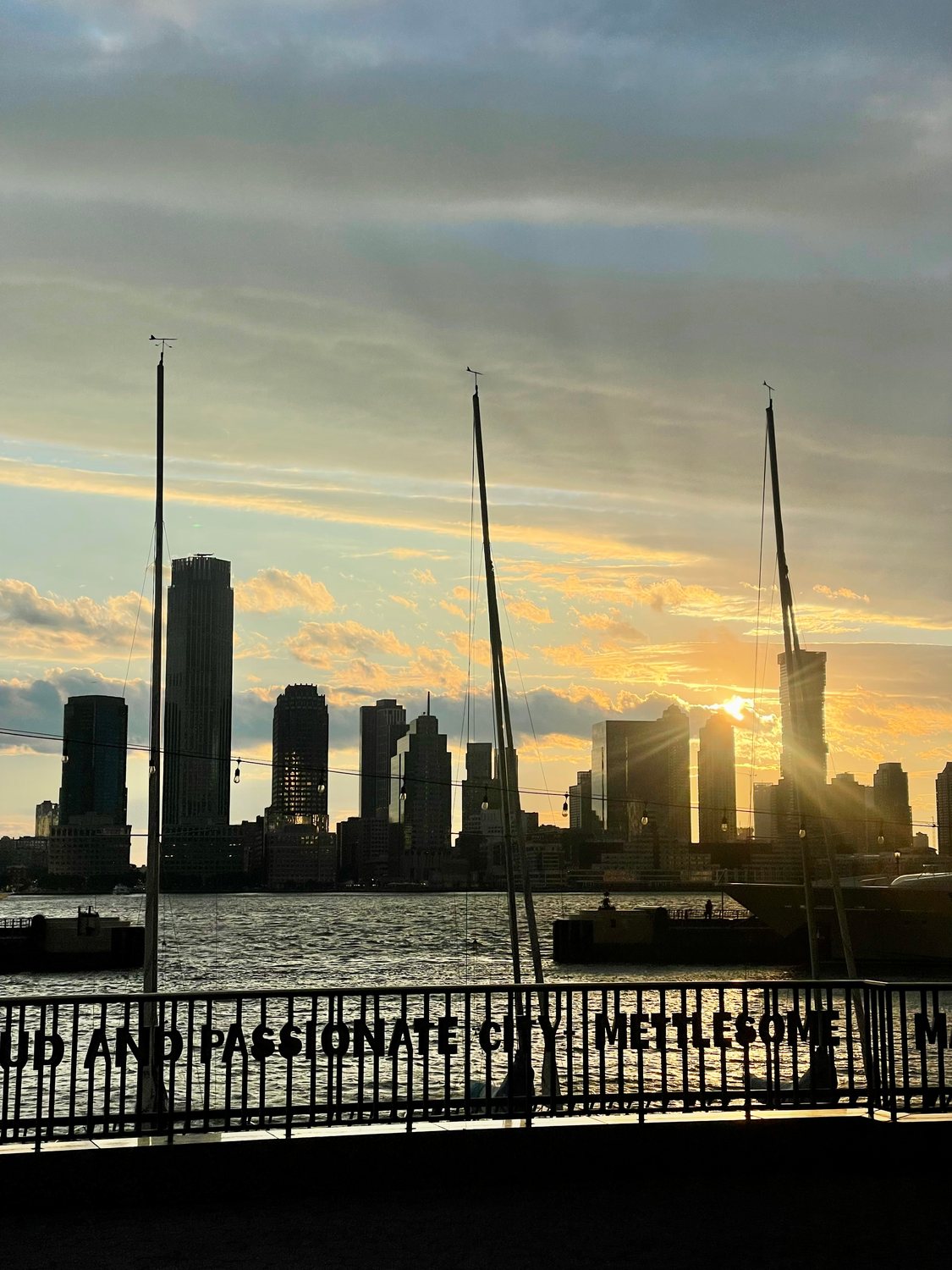 Masts and the skyline at sunset across the water