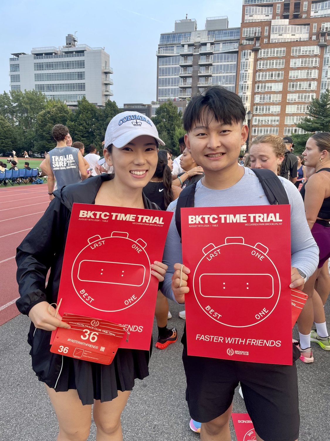 Danlin Zeng holding a Brooklyn Track Club time trial poster at the track